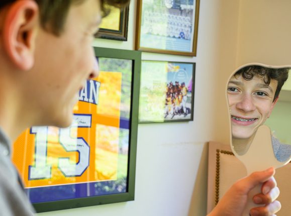 Boy looking in mirror and smiling